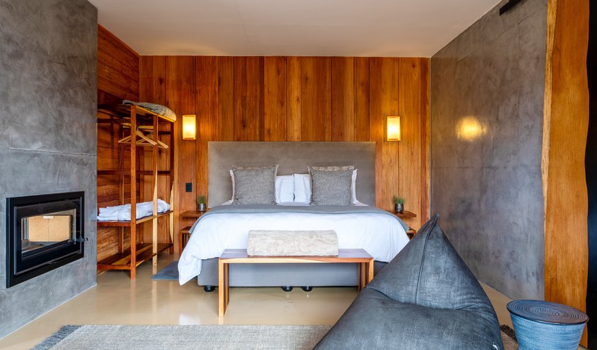 Waterfall Pod: The bedroom area is furnished with a king-size bed and features an en-suite bathroom with a bath and a shower